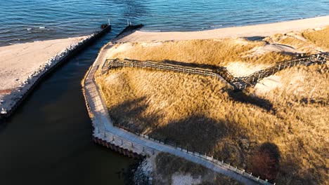 A-boardwalk-covered-in-sand-near-the-mouth-of-a-river