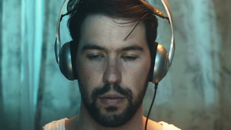 male introvert wearing vintage silver headphones, screen glare on face, frontal