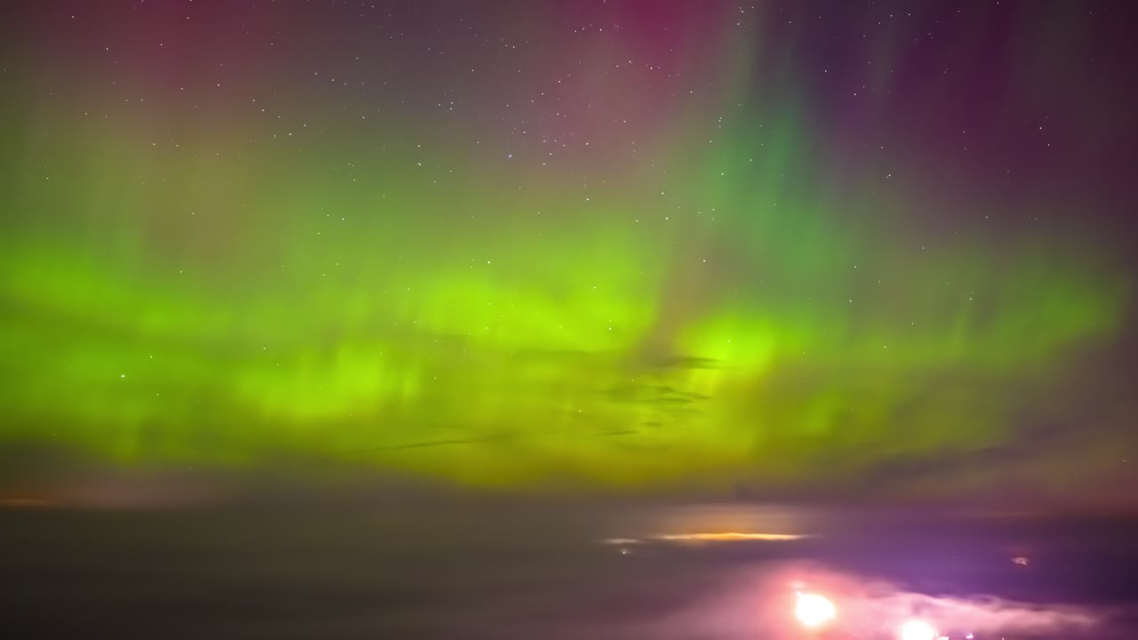 Drone-timelapse av levende nordlys som danser og skifter farger over en stjerneklar nattehimmel.