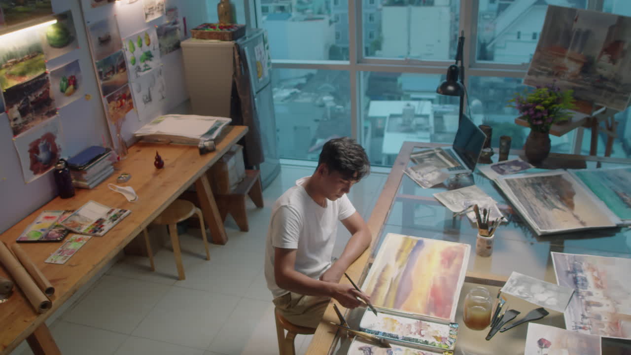 Male Artist Painting with Watercolors in Studio