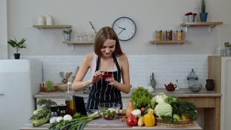 Veganes-Blogger-Mädchen-Macht-Fotos-Und-Macht-Selfies-Für-Soziale-Medien-Auf-Dem-Smartphone-In-Der-Küche