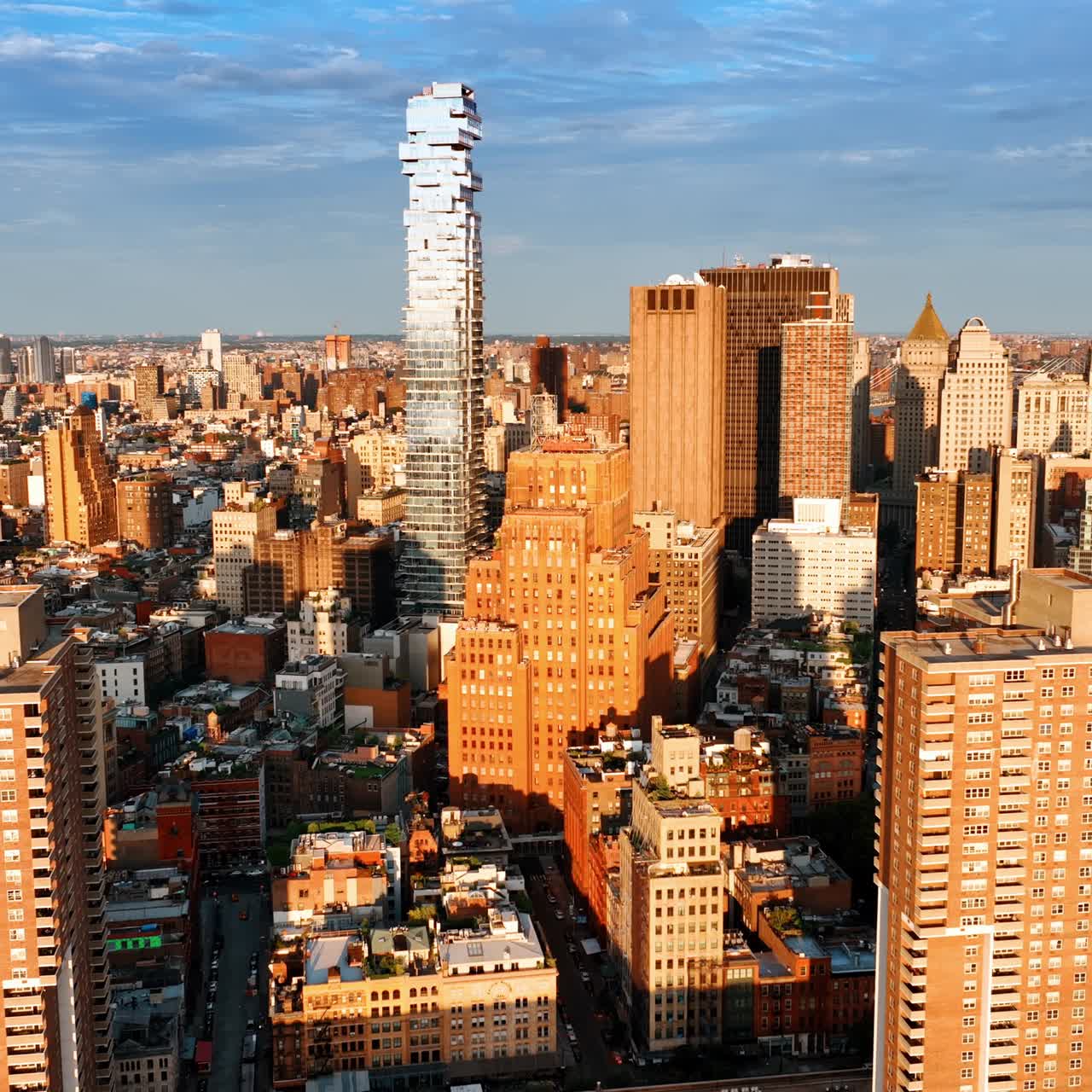 Bright sun lighting the diverse dense architecture of New York. Golden hour footage of cityscape from drone