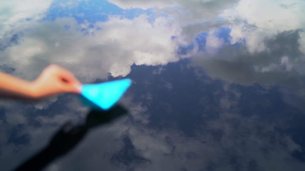 Hand and paper boat in river. Female hand starts in a stream the small paper ship