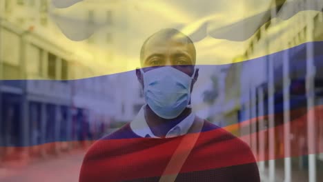 Animation-Der-Flagge-Von-Kolumbien,-Die-über-Einem-Afroamerikanischen-Mann-Mit-Gesichtsmaske-In-Der-Stadtstraße-Weht