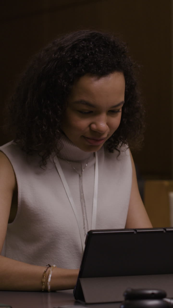 Portrait of a young woman with curly hair using a tablet