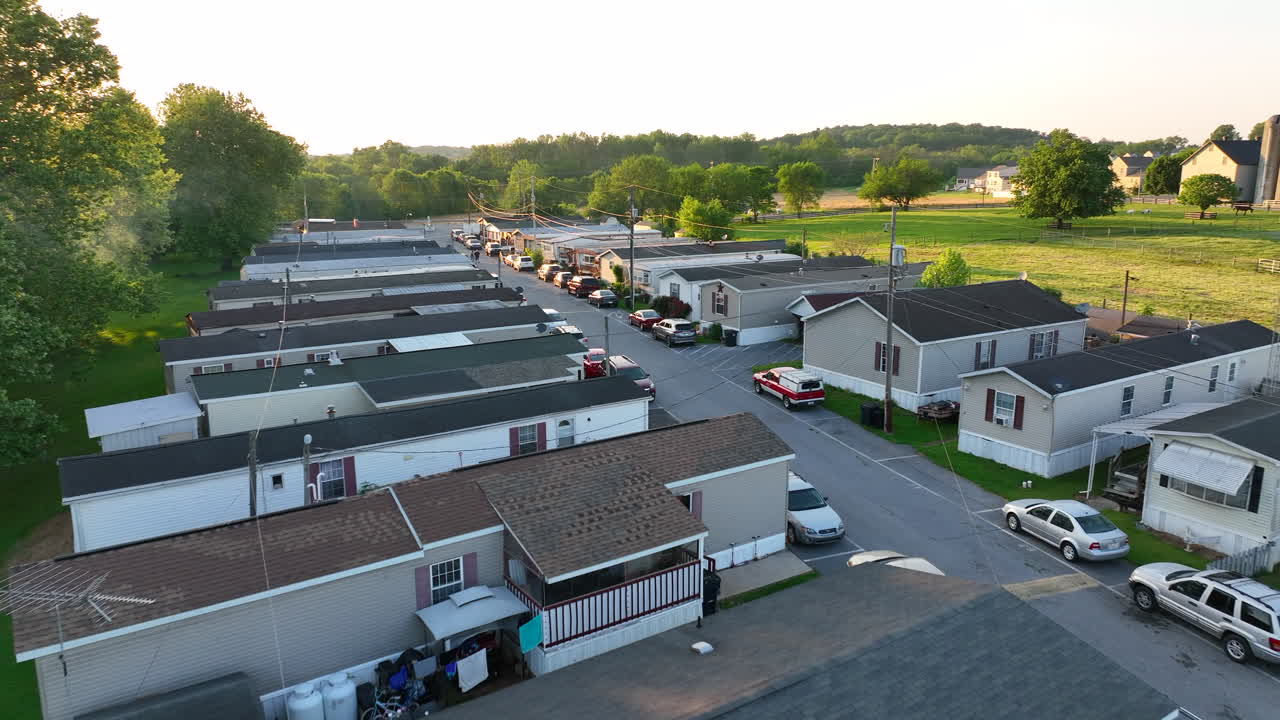 Mobile home park during beautiful golden hour sunset. Aerial flyover of small, cheap houses in rural America. Low income housing theme
