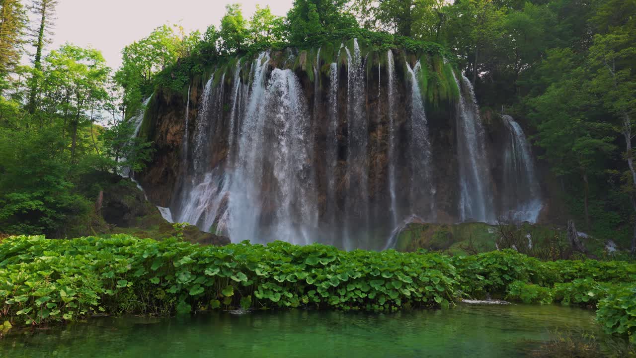 Iconic waterfall, Plitvice National Park Croatia. Forest and clear mountain river water, slow motion