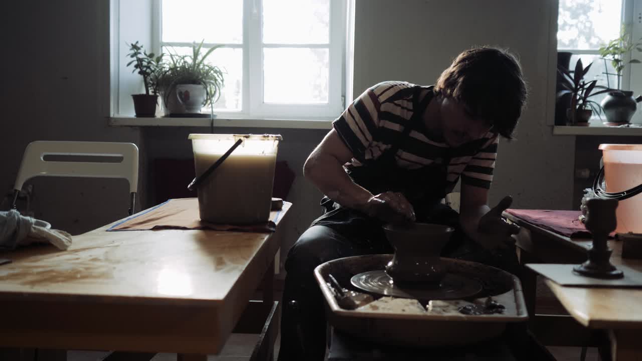 한 젊은이가 도자기 공장에서 일합니다.