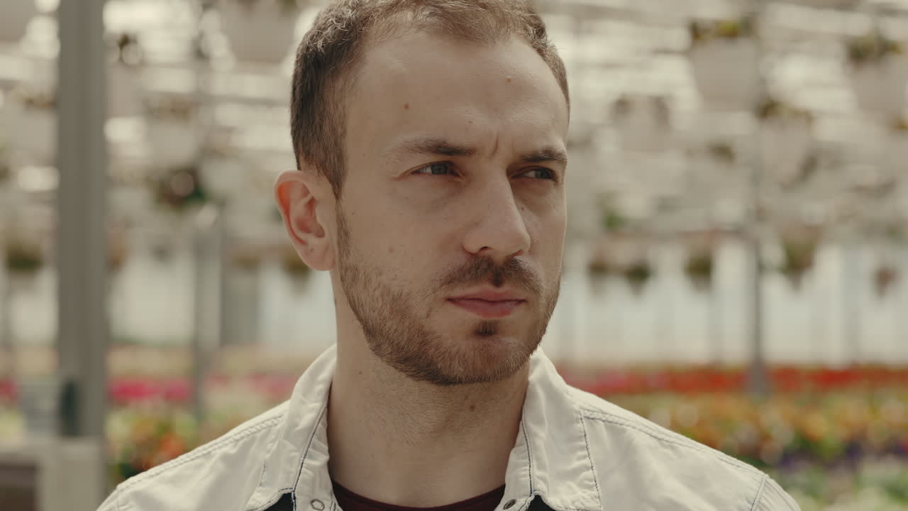 Close-up portrait of a smiling man in a greenhouse
