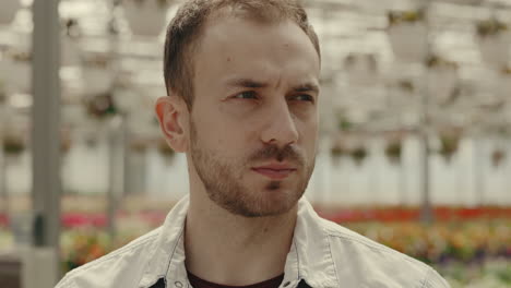 close-up portrait of a smiling man in a greenhouse