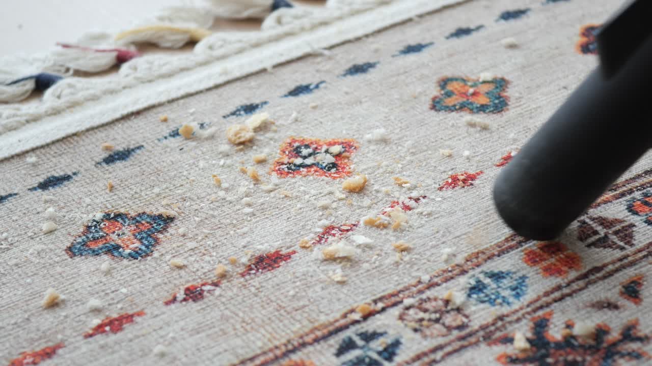 Primo piano di un aspirapolvere che pulisce un tappeto a motivi