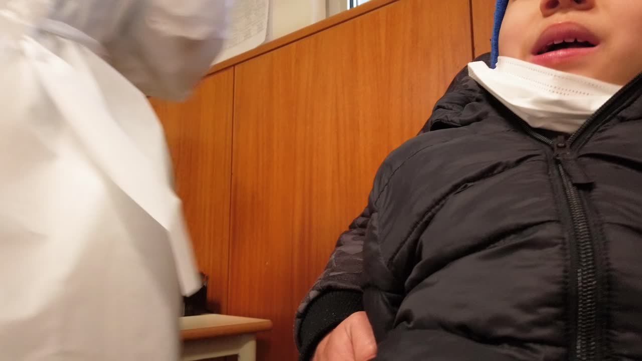 간호사는 비강 면봉을 아이의 콧구멍 안에 삽입합니다 - covid-19 테스트 절차