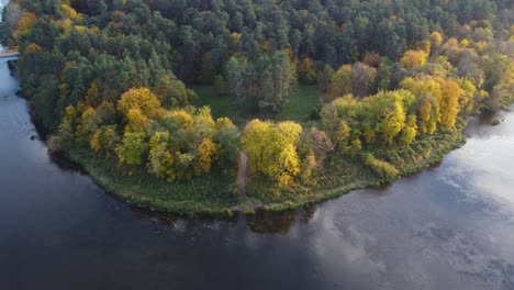 toma aérea en órbita de un recodo de un río con vibrante follaje otoñal en octubre