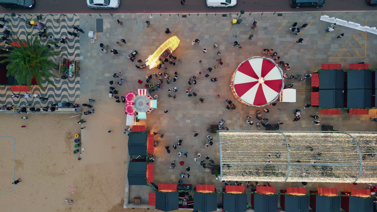 People crowds enjoying festive market top view. Evening lights twinkle festival