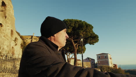 retired man looks at the landscape during a tourist visit to an italian old town