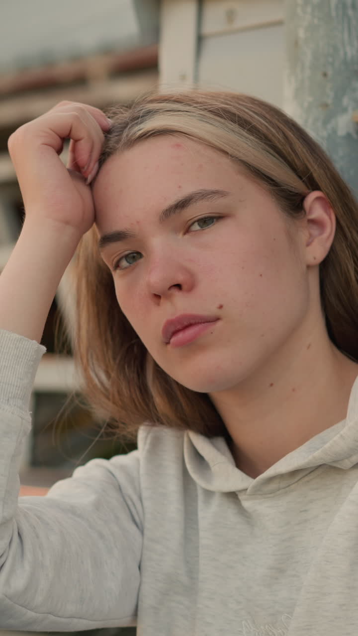 젊은 여성은 그녀의 손에 머리를 고, 깊은 성찰에 빠져, 그녀의 표정은 따뜻한 자연 조명과 함께 내성과 평온의 혼합을 드러니다.