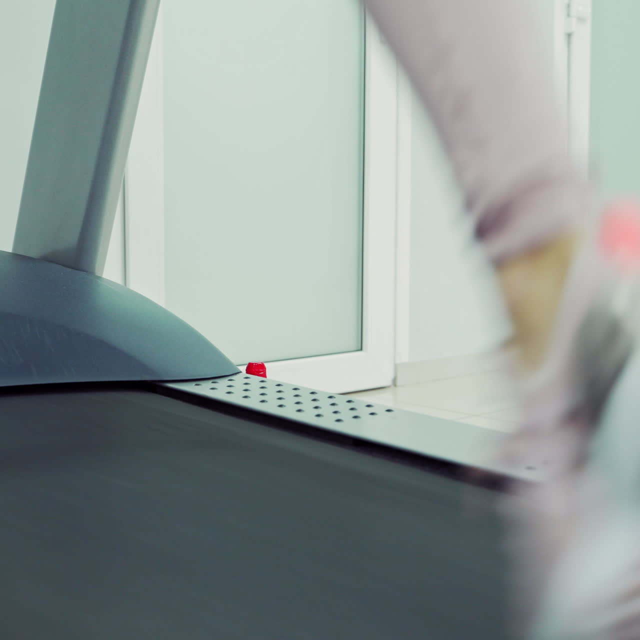 Close-up of women's legs in sport trainers running on the treadmills in a new gym. Fitness and healthy lifestyle concept.