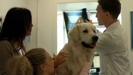 mother and daughter with dog in the vets