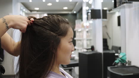Asian woman getting her hair styled in a salon