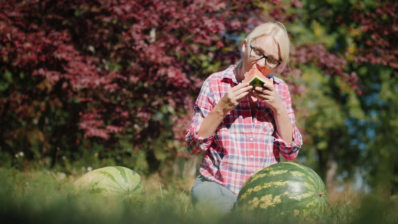 mujer comiendo sandía en un campo