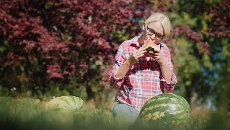 woman eating watermelon in a field