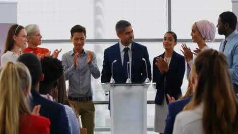 Businessman-standing-on-the-podium-with-his-colleagues-in-the-business-seminar-4k