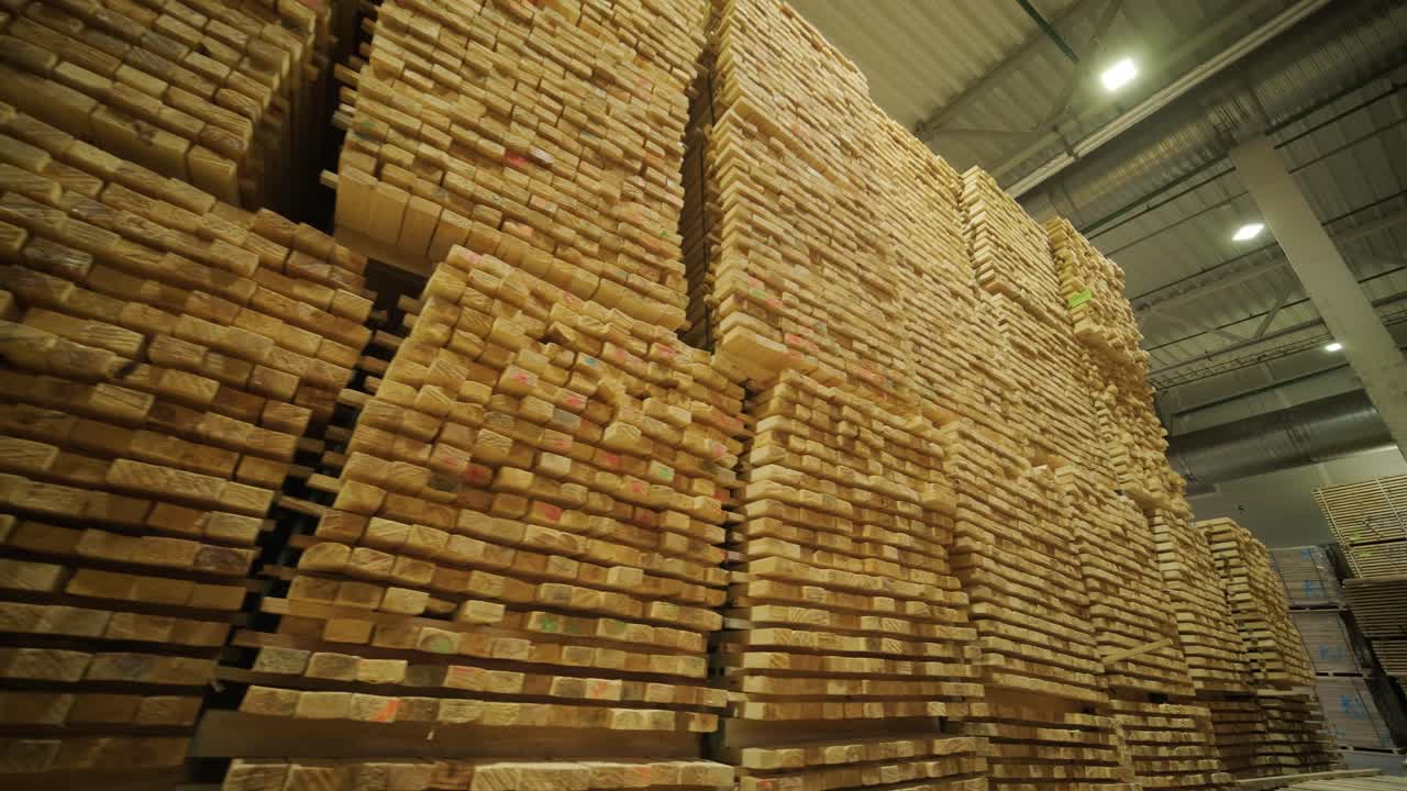 Large Stacks of Wooden Planks Stored in Industrial Warehouse