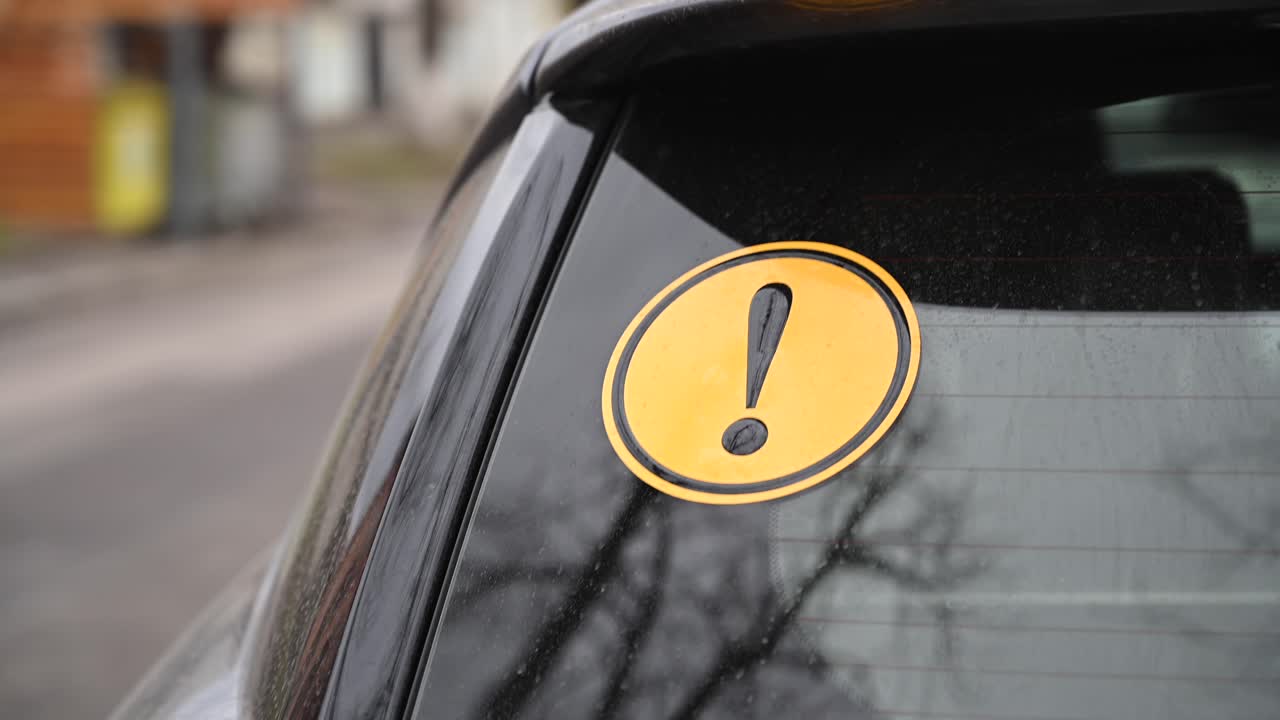 Beginner driver yellow round sign on a car. Traffic on background