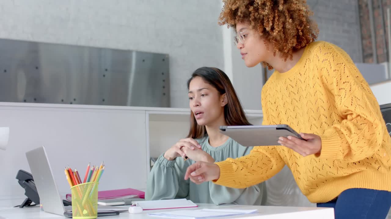 diversas compañeras usando computadoras portátiles y tabletas hablando en el escritorio en la oficina, espacio de copia, cámara lenta