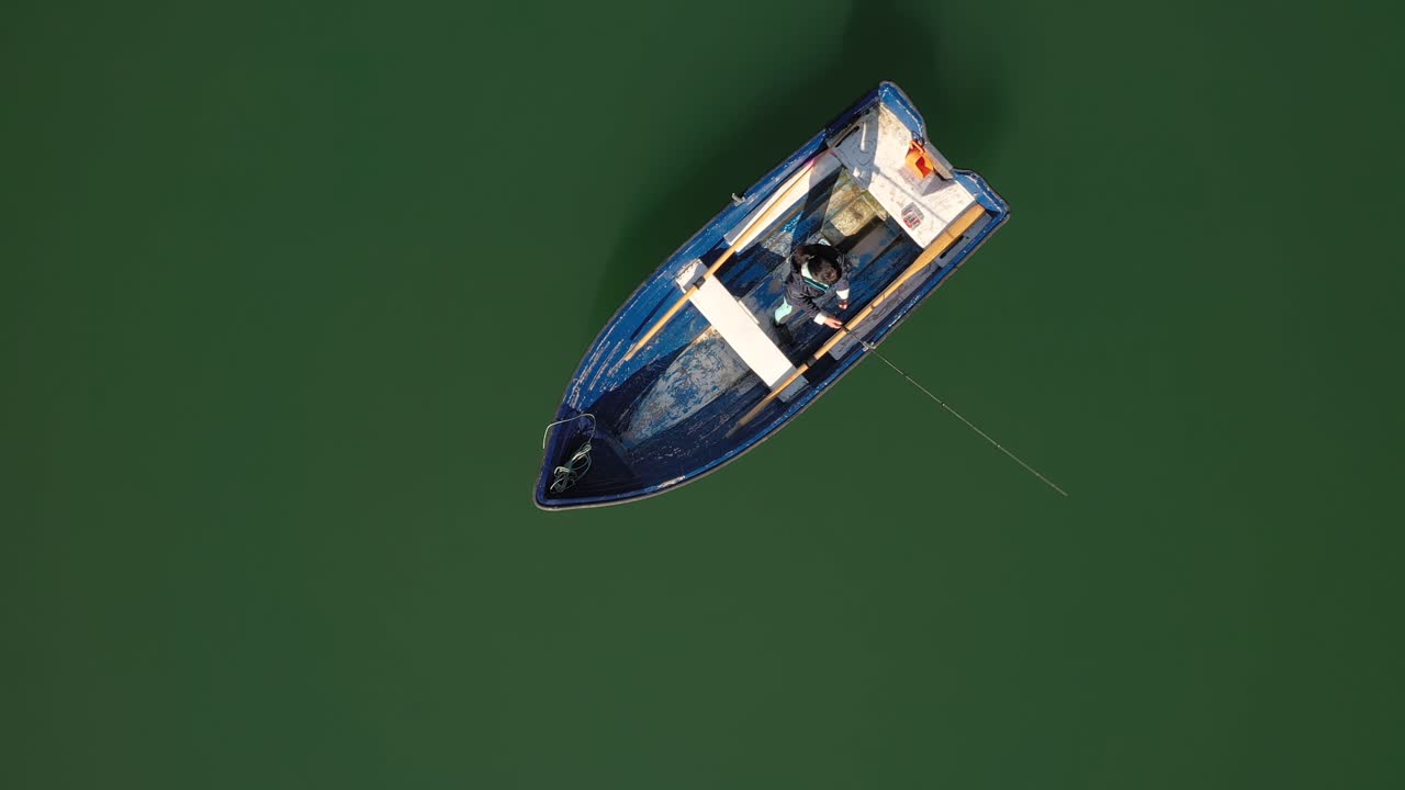 женщина на лодке ловит рыбу на вращении в норвегии.