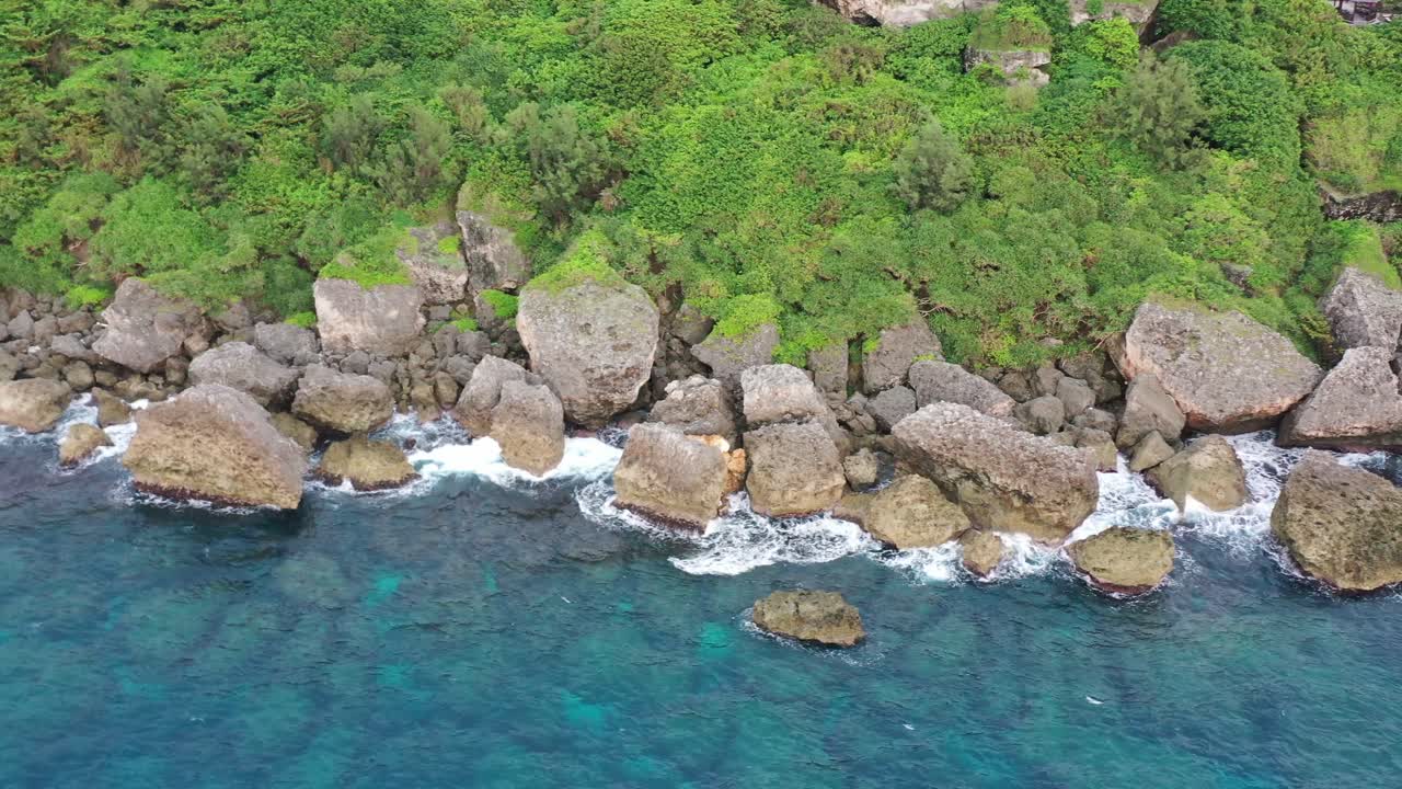 바위가 많은 해안을 따라 공중 하향식 추적 왼쪽 샷 아름다운 바다 경치와 파도가 대만 핑동 카운티 xiaoliuqiu lambai 섬에서 해안 바위를 부수고 있습니다.