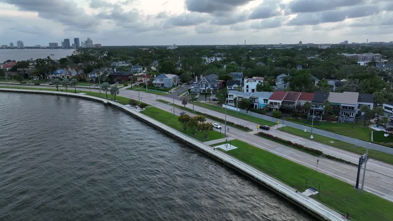 Coastal road of Tampa with luxury houses and cars on street. Aerial flyover shot. Cloudy day in Florida, USA.
