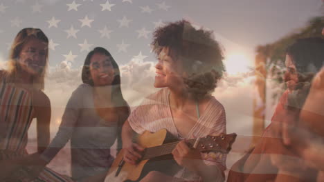 animation of flag of united states of america over happy biracial woman playing guitar on beach