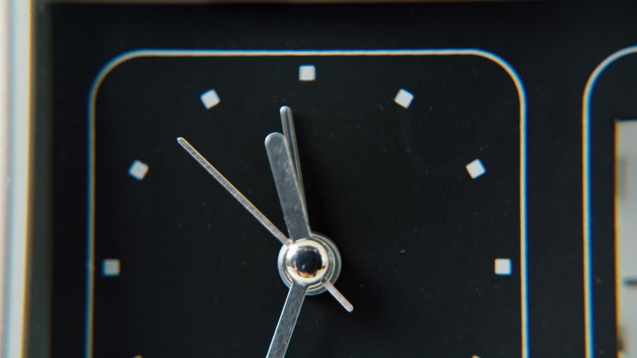 Black display retro clock showing time closeup. Macro arrow counting seconds