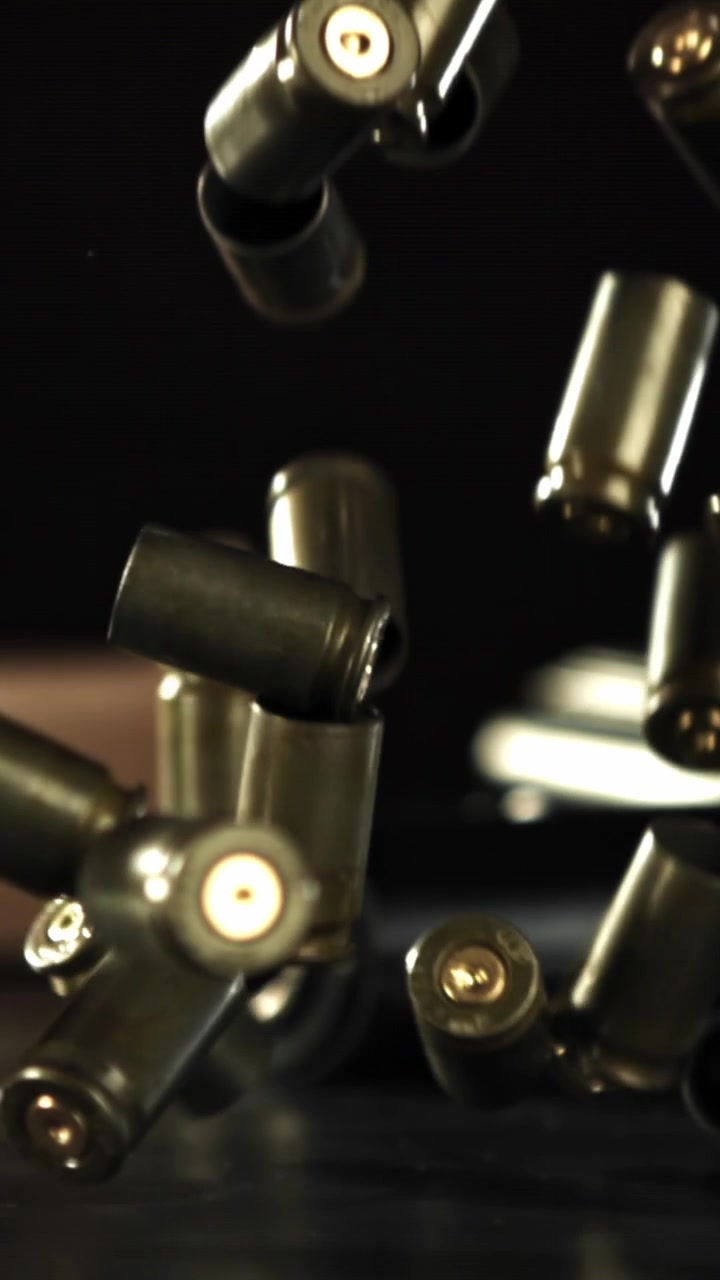 Brass Bullet Casings Falling in Slow Motion on Black Background