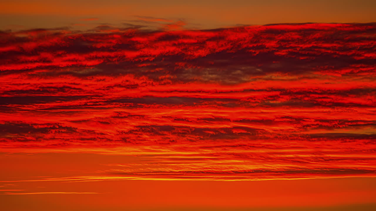 타임랩스에서 붉은 구름의 움직임과 함께 다채로운 일몰 하늘의 낮은 각도 샷