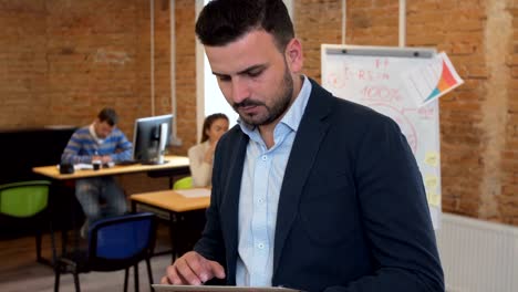 hombre usando una tableta negra con pantalla verde en una oficina moderna. fotografía con estabilizador de cámara.