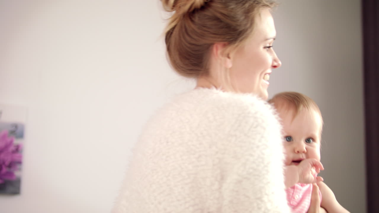 손에 작은 아기를 가진 달 ⁇ 한 어머니. 기쁜 여자 아이 소녀에게 미소