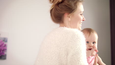 sweet mother with little baby on hands. cheerful woman smile to kid girl