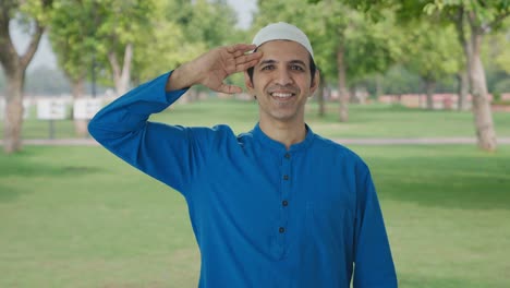 happy muslim man saluting on camera in park