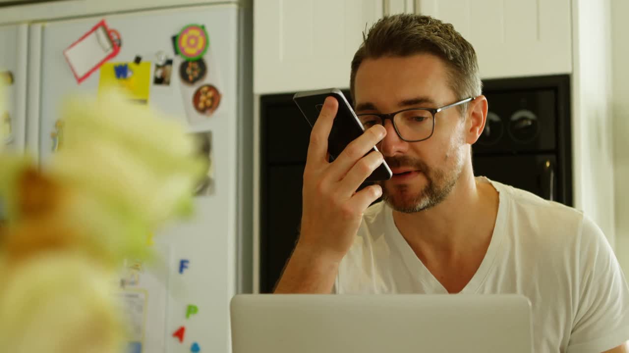 Mand taler i mobiltelefon i køkkenet 4k