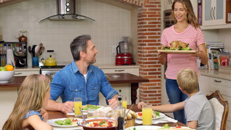 family having dinner together in kitchen