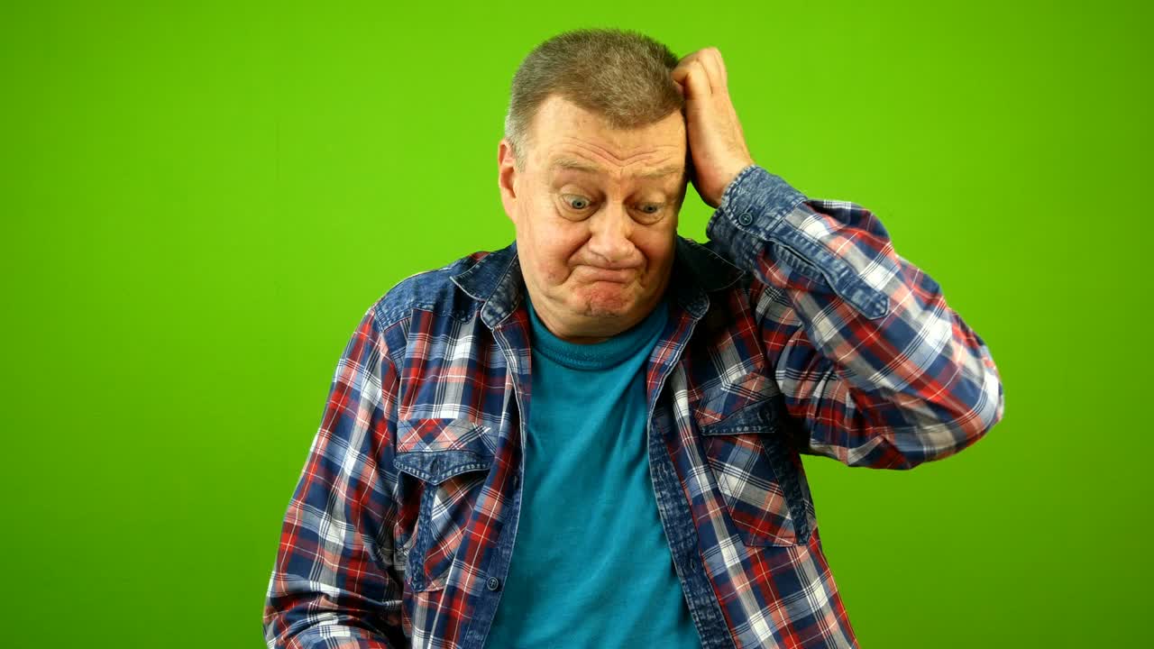 Confused puzzled, bewildered senior caucasian man in checkered shirt shrugging shoulders uncertain expression and scratching his head.