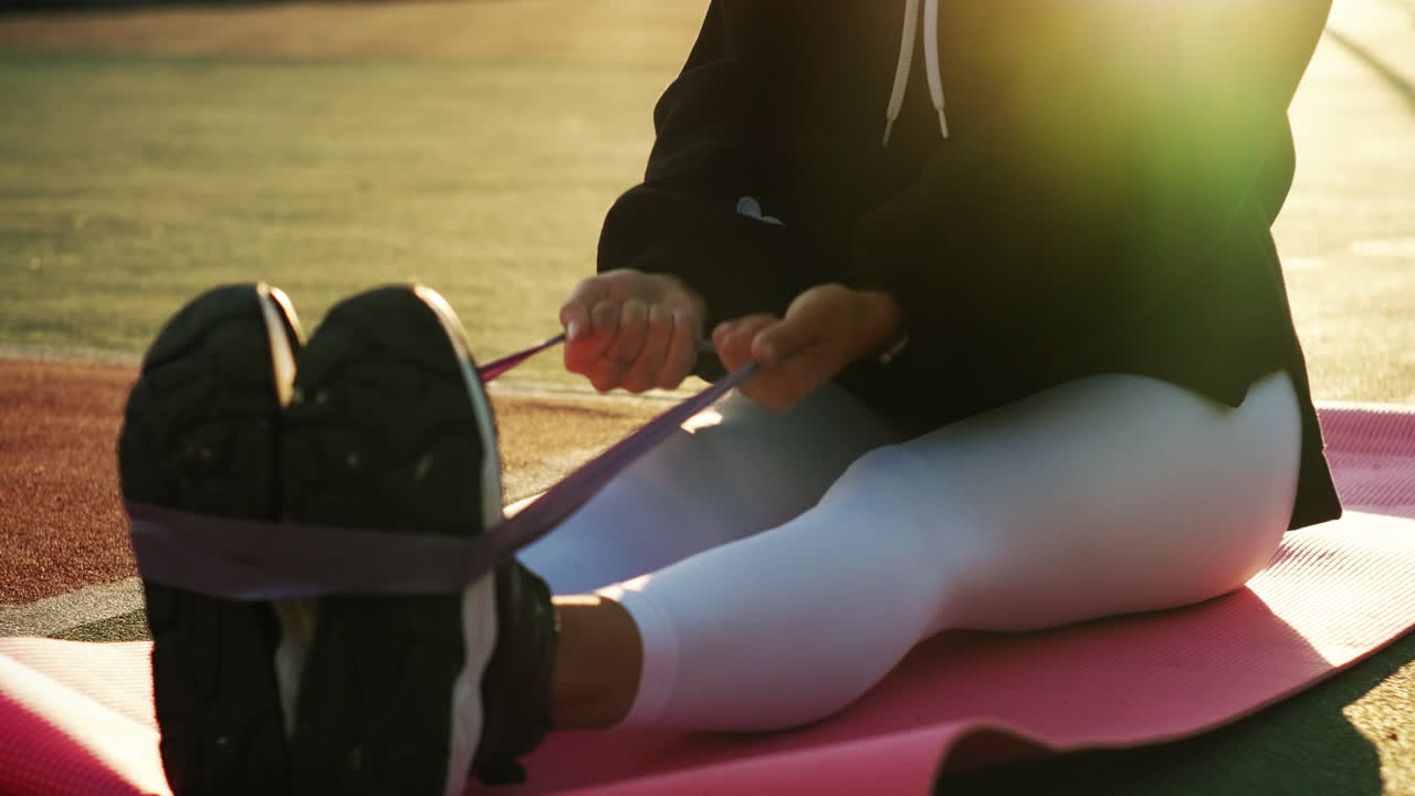 mujer estirándose con banda de resistencia