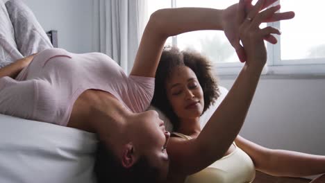 lesbian couple romancing on bed in bedroom
