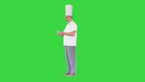 cocinero sénior en uniforme contando dinero en una pantalla verde, llave de croma