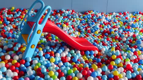 a blue and red slide in a ball pit