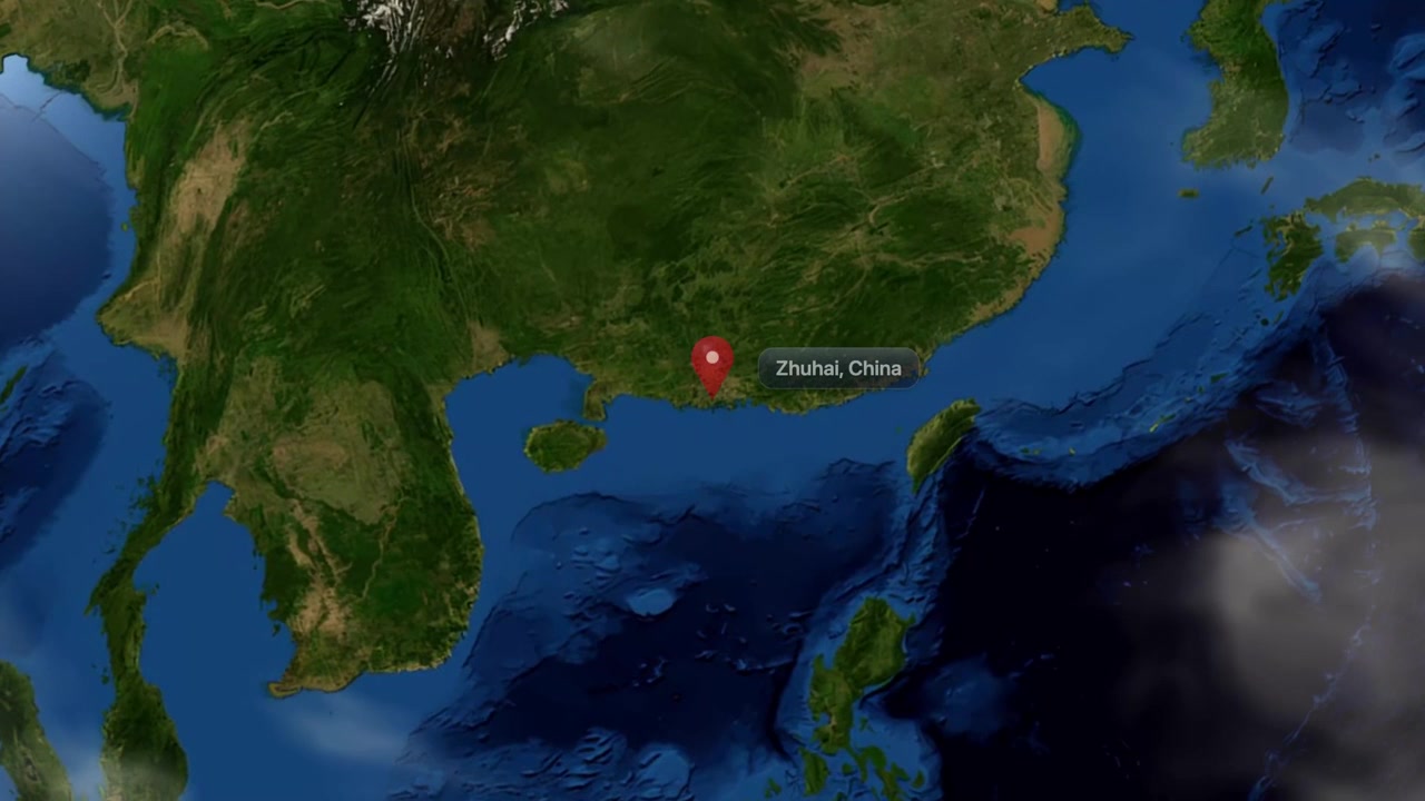 Animación satelital que hace zoom desde el espacio hacia Zhuhai, China, con un marcador de ubicación rojo. Incluye imágenes de dominio público de la NASA