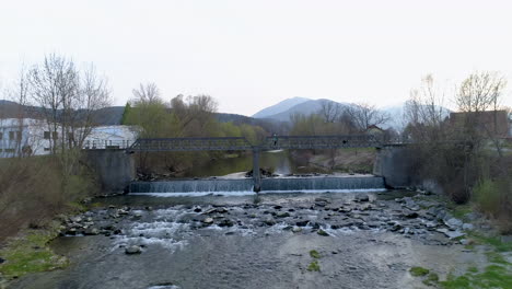 drone shot of a bridge with a person and a dog walking on it, 4k uhd