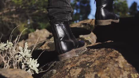 static slow motion - young woman in boots hiking mountain